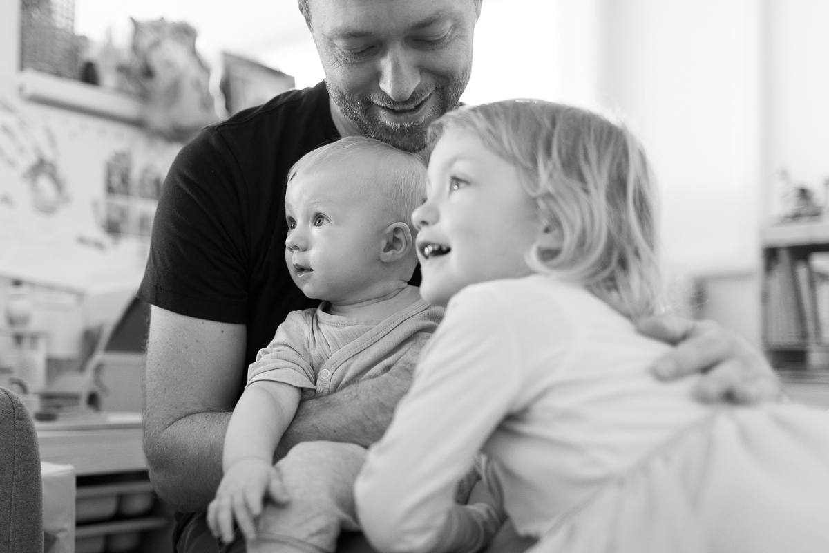 Vater mit seinen zwei lachenden Kindern, schwarz-weiß