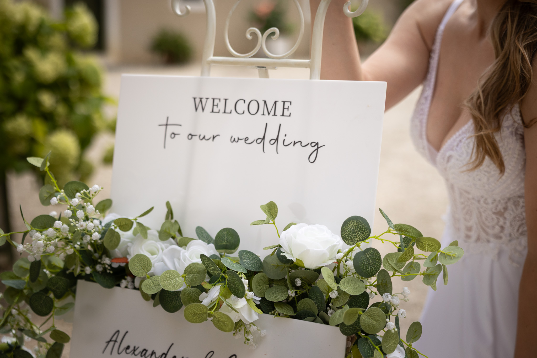 Willkommensschild der Hochzeit, Braut im Hintergrund